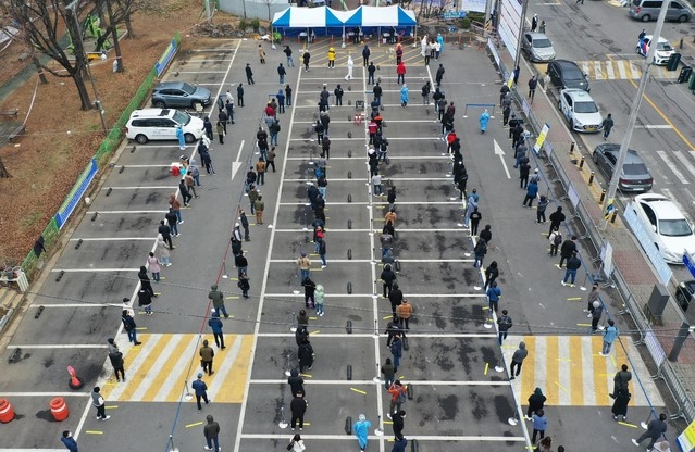 지난 21일 오전 경기도 안산시 단원구 외국인주민지원본부 인근에 설치된 임시선별검사소에서 외국인 근로자들과 시민들이 코로나19 검사를 받기위해 길게 줄 서 대기하고 있다.