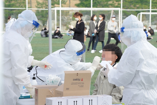 울산 동구 중학교 학생이 코로나19 확진 판정을 받은 17일 오전 해당 중학교 선별진료소에서 이 학교 학생들이 코로나19 검사를 받고 있다.