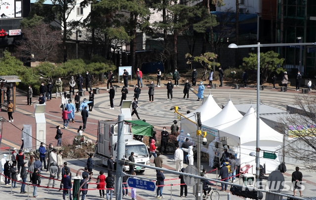 지난 22일 서울 구로구 구로역 광장 코로나19 임시선별검사소에서 외국인근로자 및 시민들이 검사를 받기 위해 줄 서 있다.