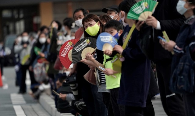 25일 일본 동북부 후쿠시마현 나라하의 2020 도쿄올림픽 성화봉송 제1 구간 봉송로에서 코로나19 확산 방지를 위해 마스크를 쓴 현지 주민들이 성화봉송 주자들을 기다리고 있다. 성화 봉송은 도쿄올림픽 개막식이 열리는 7월23일까지 121일 동안 일본 전역을 돌면서 진행된다.