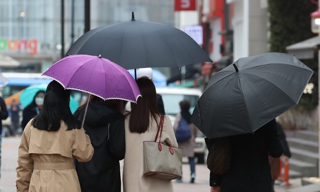 전국에 봄비가 내리기 시작한 지난 12일 서울 명동 거리에서 시민이 우산을 쓰고 있다.