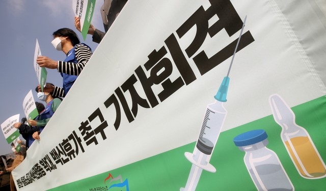 민주노총 공공운수노조 의료연대본부 조합원들이 지난 25일 오전 서울 종로구 청와대 사랑채 앞에서 열린 '모든 병원·돌봄노동자에게 백신접종 확대와 백신휴가를 촉구하는 기자회견'에서 손피켓을 들고 있다.