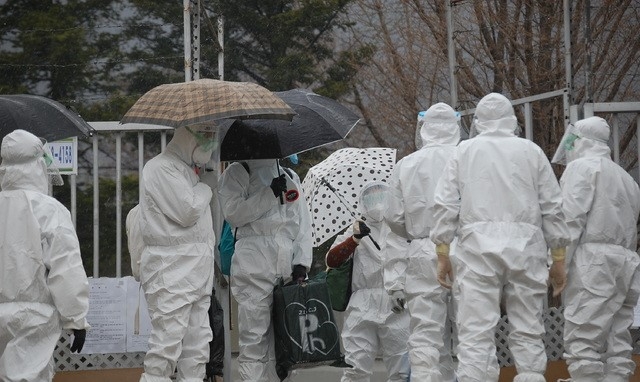 27일 오후 2시께 인천 강화군 길상면의 한 선택분교에서 발생한 코로나19 집단감염사태와 관련 분교에서 문을 잠근 채 방역 당국에 협조하지 않고 있던 확진자 4명이 방호복을 입은 채 걸어나오고 있다. 이들은 인천생활치료센터로 이송돼 치료를 받을 예정이다.