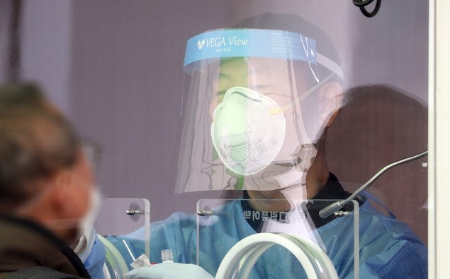 지난 29일 서울 중구 서울역광장에 마련된 코로나19 중구임시선별검사소에서 의료진이 검체 채취를 하고 있다.