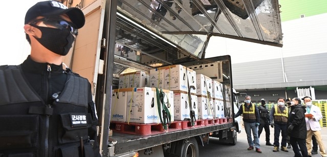지난달 31일 오전 경기도 평택시 오성면 한국초저온 물류센터에서 관계자들이 화이자와 직접 계약을 통해 확보한 백신 추가 물량 50만 회분을 수송한 백신차량을 살펴보고 있다.
