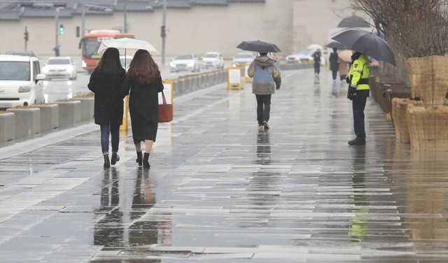 서울 지역에 비가 내리고 있는 지난 1월21일 오후 서울 종로구 광화문광장에서 우산을 쓴 시민들이 걷고 있다.