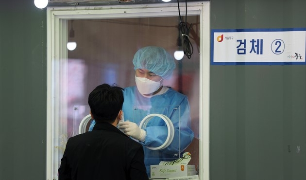 5일째 코로나19 신규 확진자가 500명대로 집계된 4일 서울 중구 서울역 광장 코로나19 중구 임시선별검사소에서 의료진이 검체를 채취하고 있다.