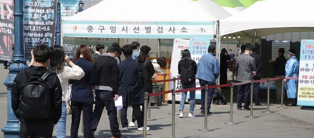 0시 기준 코로나19 일일 신규 확진자가 668명으로 집계된 7일 서울역 임시선별검사소를 찾은 시민들이 검사를 위해 줄을 서 있다.
