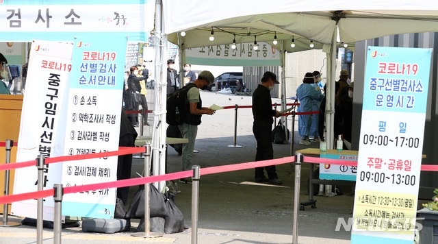  지난 10일 오전 서울 중구 서울역광장에 마련된 코로나19 임시선별검사소에서 시민들이 검체 채취를 하고 있다.