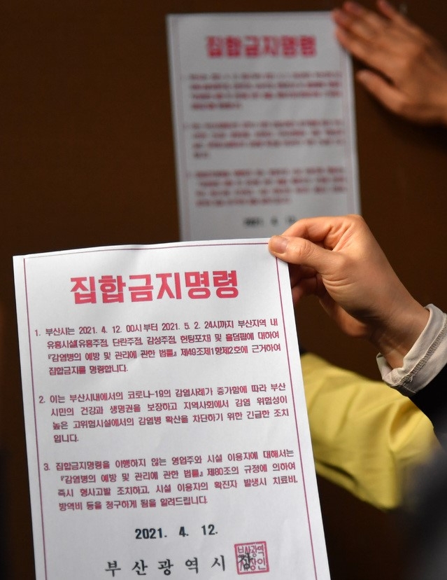 부산지역 유흥시설 집합금지 조치 첫날인 12일 오후 부산진구청 공무원들이 서면의 한 업소 출입구에 집합금지 행정명령문을 부착하고 있다. 부산시는 지난 2일부터 적용 중인 사회적 거리두기 2단계를 12일부터 5월 2일까지 3주간 연장하고, 특히 이 기간 유흥시설 5종과 홀덤펍에 대해서는 집합금지 명령을 내렸다.