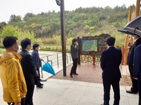 12일 비가 내리는 가운데 목포시의회 결산위원들은 삼학도 무장애 나눔길 조성 현장을 방문해 공원녹지과로부터 보고를 받은 후 현장을 살피는 등 강행군을 펼치고 있다/사진=목포시