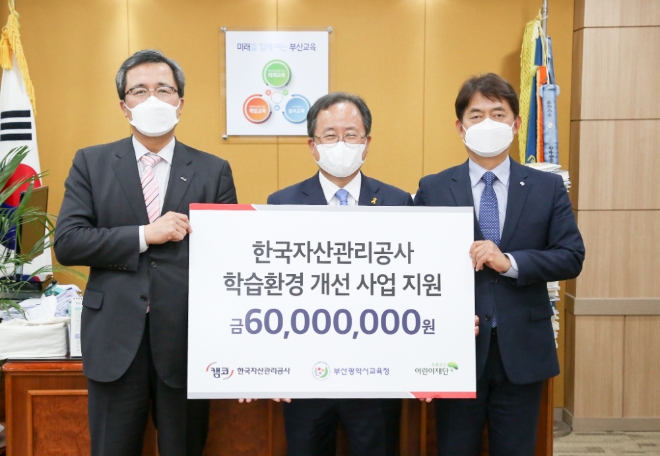 문성유 캠코 사장(사진 왼쪽)이 김석준 부산광역시 교육감(사진 중앙)에게 저소득 가정 학습환경 개선을 위한 ‘디지털 공부방’ 지원금을 전달하고 홍창표 초록우산어린이재단 부회장(사진 오른쪽)과 함께 기념촬영을 하고 있다.