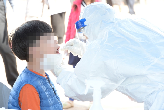 울산 울주군 한 초등학교 교사가 코로나19 확진판정을 받은 13일 오전 해당 초등학교 선별진료소에서 학생이 코로나19 검사를 받고 있다.