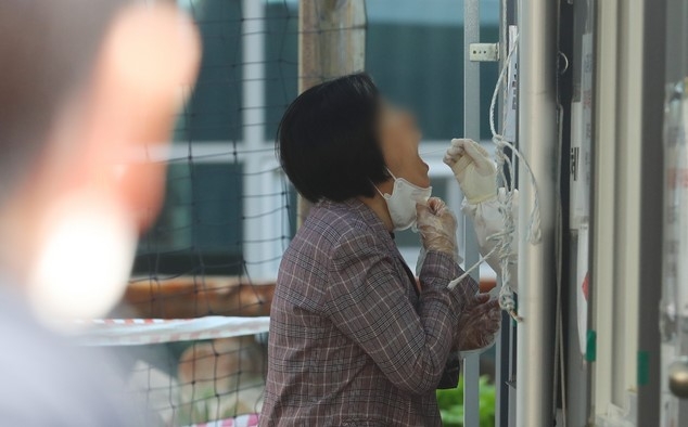 코로나19 신규 확진자가 석 달 만에 700명 대로 나타난 8일 오후 서울 성동구 코로나19 임시선별검사소에서 시민들이 검사를 받고 있다.