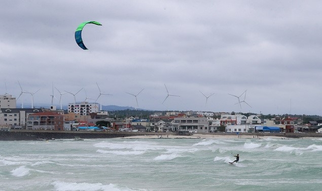흐린 날씨를 보이고 있는 제주시 구좌읍 김녕리 해변에서 한 레저객이 바람의 힘을 이용해 보드를 움직일 수 있는 카이트 서핑을 즐기고 있다.