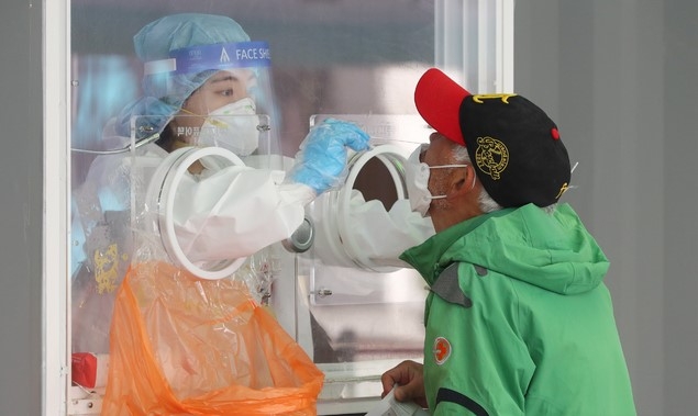 18일 오전 서울 중구 서울역 광장에 마련된 임시 선별검사소에서 한 시민이 검사를 받고 있다.