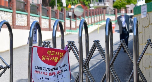 19일 오전 광주 광산구의 초등학교에서 코로나19 확진자가 발생, 임시폐쇄를 알리는 플래카드가 교문에 걸려 있다. 
