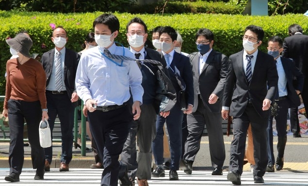 19일 일본 도쿄에서 코로나19 확산을 막기 위해 마스크를 쓴 시민들이 건널목을 건너고 있다. 고이케 유리코 도쿄도지사와 요시무라 히로후미 오사카부 지사는 "코로나19의 심각한 상황이 계속되고 있다”라며 대책 회의를 통해 긴급사태 선언 발령을 국가에 요청할 것을 시사했다.