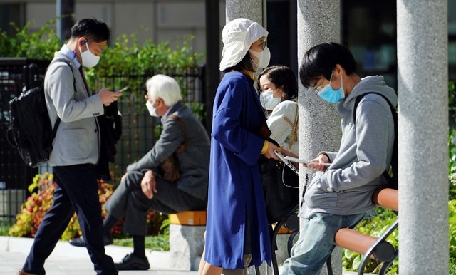 15일 일본 도쿄의 한 공원에서 시민들이 코로나19 감염 예방을 위해 마스크를 착용한 채 오후를 즐기고 있다.