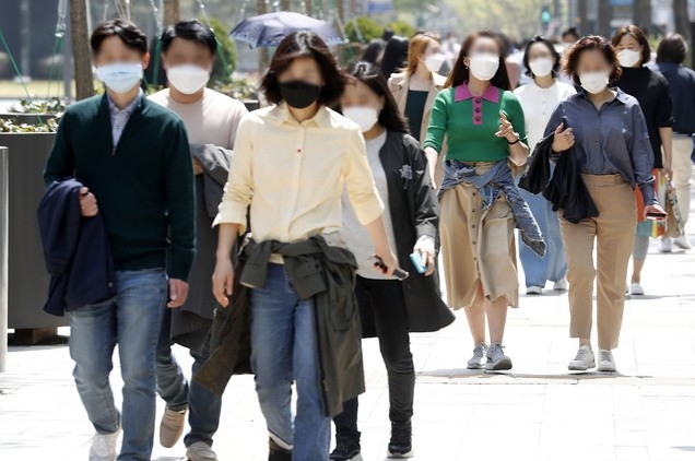 서울 낮 최고 기온이 28도로 무더운 날씨를 보인 지난 21일 서울 중구 청계광장 인근에서 겉옷을 들거나 허리에 두른 채 발걸음을 옮기고 있다.