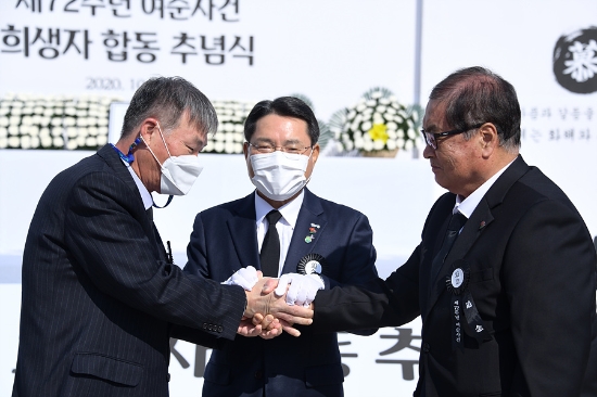 지난해 10월 19일 순직 경찰 유족이 함께하면서 최초로 민‧관‧군‧경이 하나 된 ‘제72주년 여순사건 합동 추념식’에서 윤정근 여순사건 유족회장(왼쪽)과 남중옥 순직 경찰 유족대표(오른쪽)가 여순사건 특별법 제정을 목표로 화해와 상생을 다짐하며 손을 잡고 있다./사진=여수시