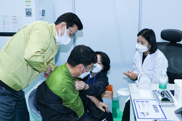 허태정 대전시장이 유성접종센터 현장에서 화이자 백신을 맞고 있는 시민을 살펴보고 있다.