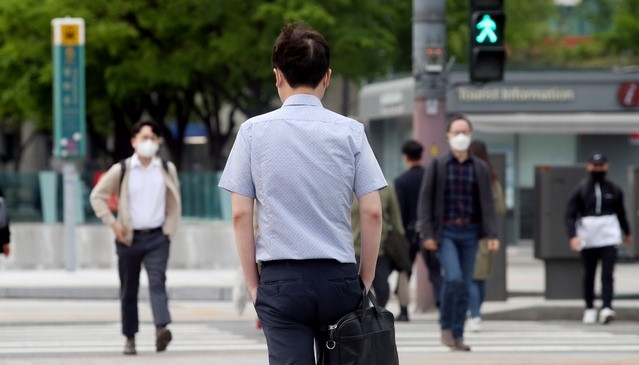 지난 22일 오전 서울 종로구 광화문네거리에서 한 시민이 반팔 옷을 입고 출근하고 있다.