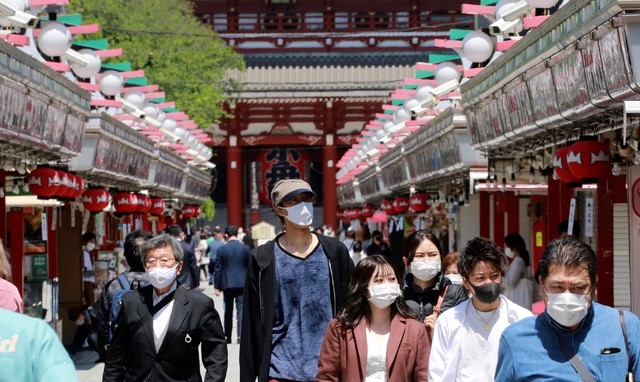26일 일본 도쿄의 아사쿠사 지구에서 코로나19 확산을 막기 위해 마스크를 쓴 시민들이 거리를 거닐고 있다. 일본은 2020 도쿄올림픽을 3개월 남기고 늘어가는 코로나19를 억제하기엔 기간이 충분하지 않을 것이라는 회의적인 시각 속에 25일 오사카부와 도쿄도, 효고현, 교토부 등 4개 도부현에 긴급사태 선언을 재선포했다.