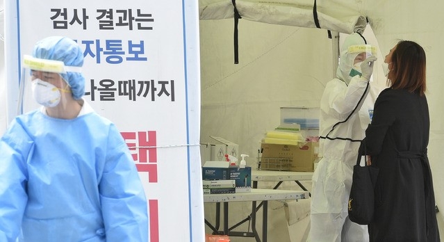 대구 지역 코로나19 확진자가 12명으로 집계된 27일 대구 중구 국채보상운동기념공원에 마련된 임시선별검사소에서 의료진이 검체를 채취하고 있다.