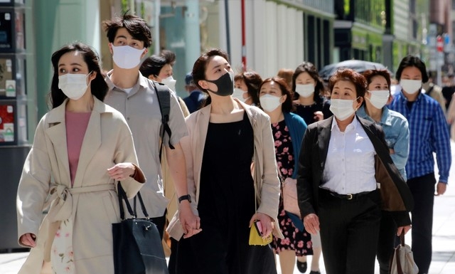 일본 수도 도쿄의 번화가 긴자에서 26일 코로나19 예방을 위해 마스크를 착용한 시민들이 걸어가고 있다.