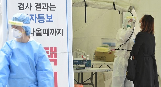 지난 27일 대구 중구 국채보상운동기념공원에 마련된 임시선별검사소에서 의료진이 검체를 채취하고 있다.