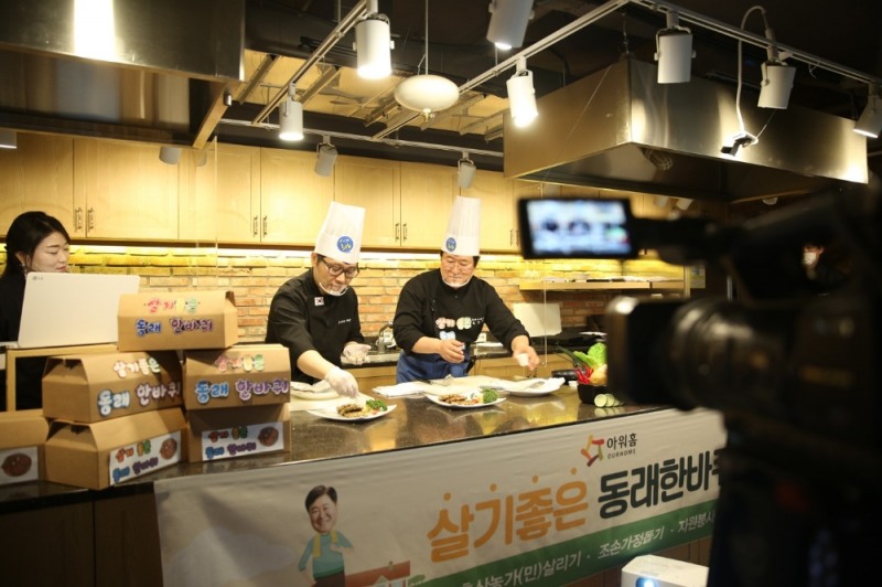 사진=아워홈 양산2센터 오키친에서 열린 비대면 쿠킹클래스에서 김우룡 동래구청장(오른쪽)과 아워홈 김기철 셰프(왼쪽)이 돼지떡갈비를 만들고 있다.