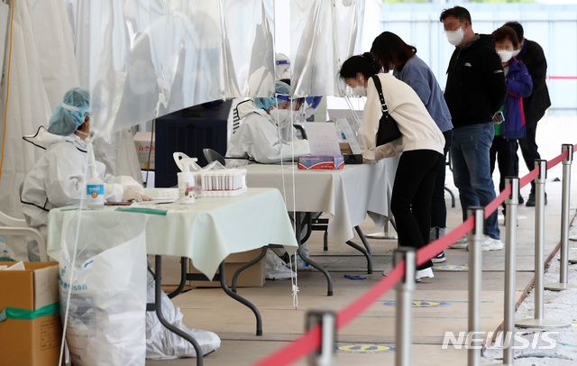 지난 29일 오후 서울 강서구 마곡8구역 공영주차장에 마련된 코로나19 임시선별검사소에서 시민들이 검사를 받기위해 본인확인을 하고 있다.