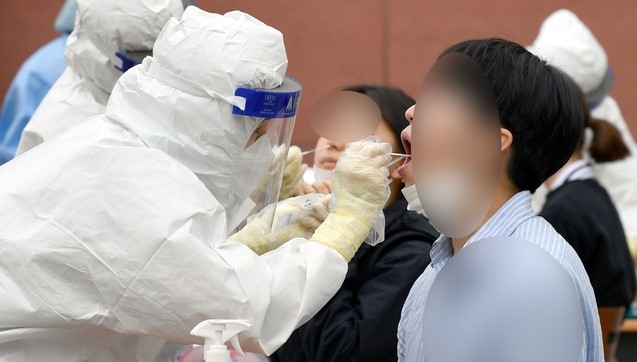 지난달 22일 오후 광주 북구 한 고등학교 주차장에 설치된 임시선별검사소에서 방역당국이 학생과 교사 등을 대상으로 코로나19 전수검사를 하고 있다.