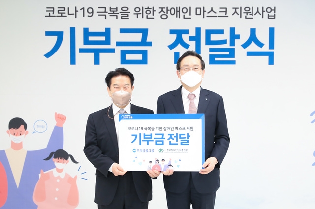 우리금융그룹은 4일 서울시 중구 소재 우리은행 본점에서 ‘코로나19 극복을 위한 장애인 마스크 지원사업’ 기부금 전달식을 열었다. 손태승(오른쪽) 우리금융그룹 회장과 최공열(왼쪽) 한국장애인단체총연맹 상임대표가 기념촬영을 하고 있다. (사진=우리금융그룹 제공)