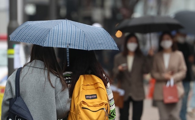 전국에 봄비가 내리기 시작한 지난 3월12일 서울 명동 거리에서 시민이 우산을 쓰고 있다. 