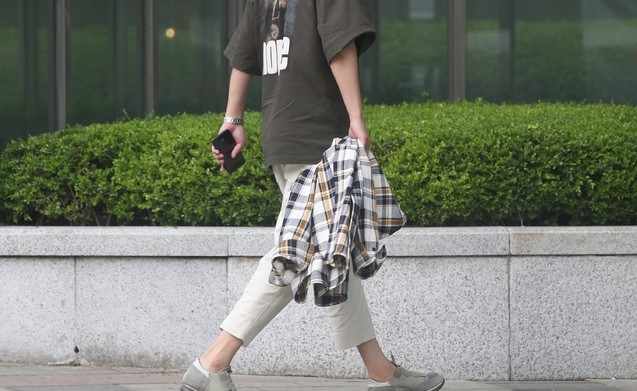 지난달 22일 오전 서울 종로구 광화문네거리에서 한 시민이 반팔 옷을 입고 출근하고 있다. 