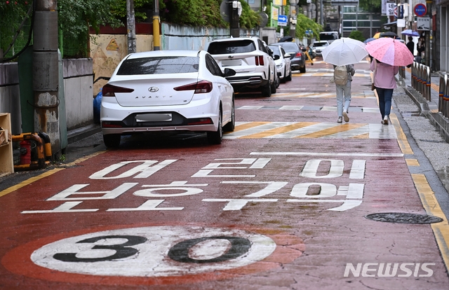 지난 10일 오후 경기도 수원시 영통구 한 초등학교 인근 어린이보호구역(스쿨존)에 불법주차한 차량들이 줄지어 서 있다. 11일부터 도로교통법 시행령 개정으로 어린이보호구역 내 불법주정차 과태료는 승용차 기존 8만원에서 12만원, 승합차는 9만원에서 13만원으로 상향된다.