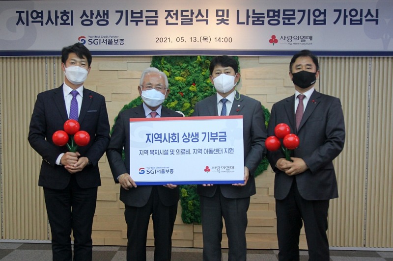SGI서울보증 유광열 대표이사(가운데 오른쪽)과 서울 사랑의열매 윤영석 회장(가운데 왼쪽)이 함께 기부금 전달판을 들고 기념촬영을 하고 있다.