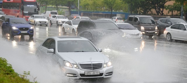 전북지역에 새벽부터 비가 내리기 시작한 11일 전주시 덕진구 백제대로에서 운전자들이 빗물에 잠긴 차도를 지나고 있다.