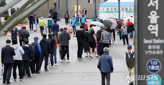 지난 17일 오전 서울 중구 서울역 임시선별검사소를 찾은 시민들이 코로나19 진단검사를 받기 위해 줄을 서고 있다.