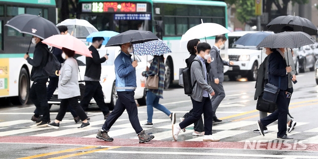 이슬비가 내리고 있는 지난 17일 오전 서울 영등포구 여의도역 인근에서 시민들이 우산을 쓰고 걸어가고 있다.