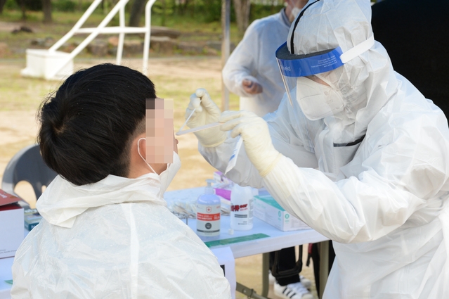울산 남구 고등학교 학생이 코로나19 확진판정을 받은 20일 오전 해당 고등학교 임시 선별검사소에서 한 학생이 코로나19 검사를 받고 있다.