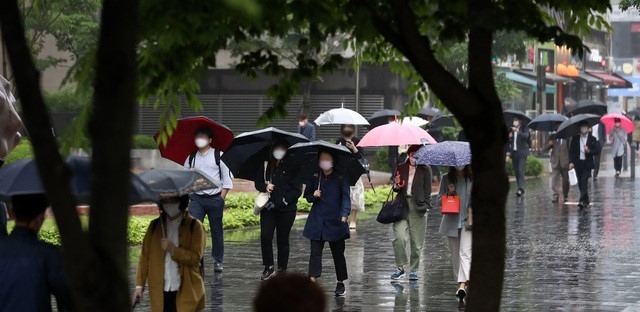 절기상 소만을 하루 앞둔 20일 오후 서울 종로구 광화문사거리에서 시민들이 우산을 쓴 채 퇴근길 발걸음을 재촉하고 있다.