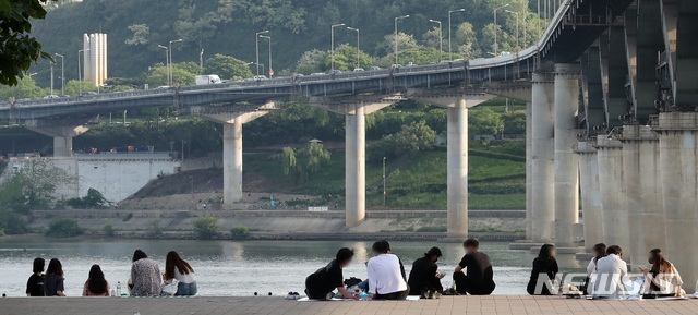 서울의 낮기온이 30도 가까이 오른 지난 14일 오후 서울 광진구 뚝섬한강공원에서 시민들이 시간을 보내고 있다.