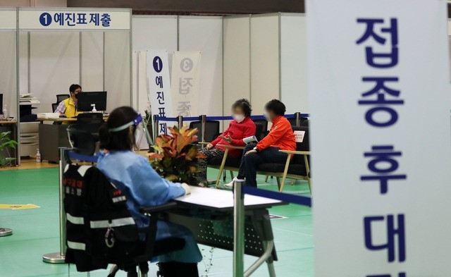 75살 이상 어르신을 대상으로 화이자 백신 1차 접종이 다시 시작된 22일 서울 노원구 코로나19 예방접종센터에서 접종을 받은 어르신과 보호자가 대기실에 앉아 있다. 이날 코로나19 신규 확진자는 666명으로 집계됐다.