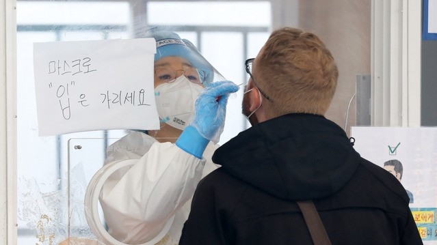 코로나19 신규 확진자가 561명으로 집계된 21일 오전 서울 중구 서울역광장에 마련된 코로나19 중구임시선별검사소에서 의료진이 검체 채취를 하고 있다.