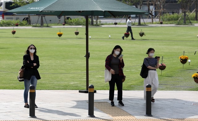 서울 낮 기온이 30도까지 오르며 초여름 날씨를 보인 14일 오후 서울 중구 시청 앞 광장에서 시민들이 횡단보도를 건너기 전 그늘막에서 햇볕을 피하고 있다.