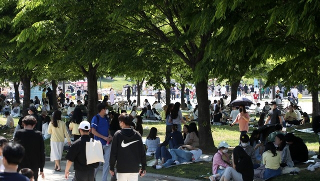 부처님오신날인 19일 서울의 한 낮 기온이 27도로 초여름 날씨를 보인 가운데 여의도 한강공원에 시민들이 나무 그늘 아래서 휴일을 즐기고 있다.