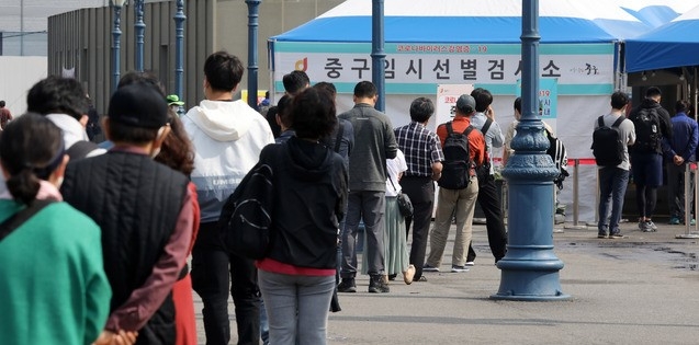 코로나19 신규 확진자가 666명으로 집계된 22일 오전 서울 중구 서울역광장에 마련된 코로나19 중구임시선별검사소에서 시민들이 검사를 받기 위해 줄 서 있다.
